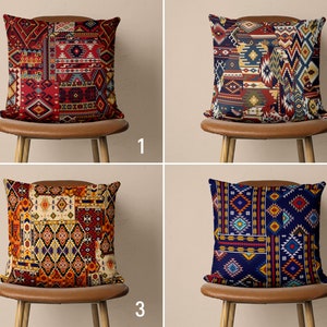 Könnte beinhalten: Vier Kissen mit verschiedenen geometrischen Mustern in Rot-, Blau-, Gelb- und Weißtönen. Die Kissen liegen auf braunen Stühlen mit Holzbeinen.