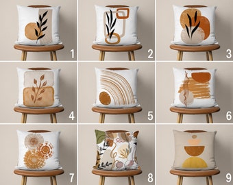 Könnte beinhalten: Neun verschiedene Designs für Dekokissen mit abstrakten Mustern in Braun-, Beige- und Weißtönen. Die Kissen zeigen geometrische Formen, Blätter und Wirbel.
