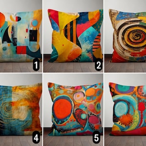 May include: Six colourful throw pillows with abstract designs. The pillows feature a variety of colours, including yellow, blue, red, orange, and green. The designs are geometric, abstract, and swirling.