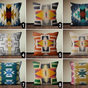 Op de afbeelding: Negen verschillende kussenhoezen met geometrische patronen in tinten blauw, geel, oranje, rood en grijs. De patronen zijn geïnspireerd op Native American designs.