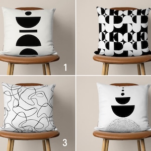 May include: Four different black and white geometric pillow designs on brown chairs. The designs include abstract shapes, lines, and circles.