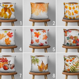 Peut inclure: Neuf designs différents d'oreillers décoratifs avec des motifs de feuilles d'automne. Les oreillers sont tous blancs avec une variété de couleurs d'automne, y compris le rouge, l'orange, le jaune et le brun. Les oreillers sont disposés en trois rangées de trois, chaque rangée présentant un motif différent.