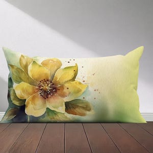 Peut inclure: Un oreiller en aquarelle avec une fleur jaune et des feuilles vertes sur un fond vert clair.