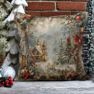 May include: A decorative throw pillow with a vintage Christmas scene featuring a snowy village with a church, trees, and a red ribbon. The pillow has a beige background with a brown border.