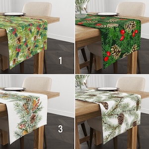 Puede incluir: Cuatro caminos de mesa diferentes con un tema navideño. Cada camino de mesa presenta un diseño de ramas de pino verdes con piñas y bayas rojas. Los caminos de mesa se muestran en mesas de madera con sillas.