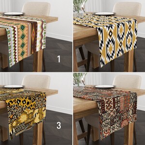 Pode incluir: Quatro caminhos de mesa decorativos com diferentes padrões são exibidos numa mesa de madeira. Os padrões incluem desenhos geométricos, motivos tribais e estampas de animais em várias cores como dourado, preto, castanho e verde. Cada caminho de mesa é retangular.