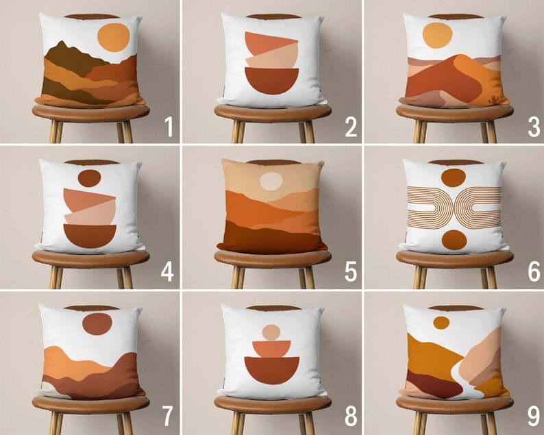 Pu&ograve; includere: Nove diversi design di cuscini con uno sfondo bianco e vari motivi astratti in tonalit&agrave; di marrone, arancione e giallo. I cuscini sono esposti su sedie in legno con una finitura marrone chiaro.