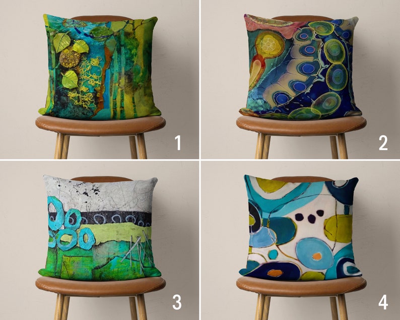 May include: Four decorative throw pillows with abstract designs in shades of blue, green, and yellow. The pillows are displayed on brown chairs with wooden legs.