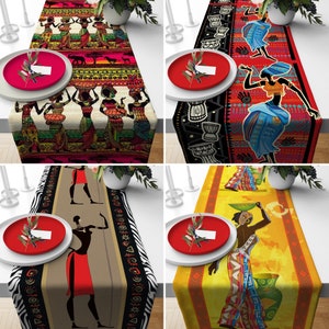 Peut inclure: Quatre chemins de table aux motifs d'inspiration africaine. Chaque chemin de table présente un motif différent avec des couleurs vives, notamment le rouge, le bleu, le jaune et le noir. Les motifs comprennent des formes géométriques, des figures stylisées et des motifs animaliers.