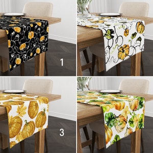 Puede incluir: Cuatro caminos de mesa diferentes con un tema de calabaza. El primer camino de mesa es negro con calabazas y enredaderas blancas. El segundo camino de mesa es blanco con calabazas y enredaderas negras. El tercer camino de mesa es blanco con calabazas y hojas amarillas y naranjas. El cuarto camino de mesa es blanco con hojas verdes y calabazas amarillas y naranjas.