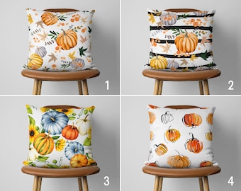 May include: Four different pillow designs featuring various pumpkin patterns. The pillows are white with orange, yellow, and blue pumpkins. The first pillow has a white background with orange pumpkins, green leaves, and small white flowers. The second pillow has a white background with black and white stripes and orange pumpkins with green leaves. The third pillow has a white background with orange, yellow, and blue pumpkins, green leaves, and yellow sunflowers. The fourth pillow has a white background with orange pumpkins and black outlines.