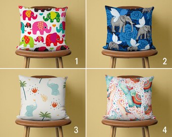Peut inclure: Quatre coussins décoratifs avec différents motifs représentant des éléphants. Les coussins sont sur des chaises brunes avec un fond jaune clair.