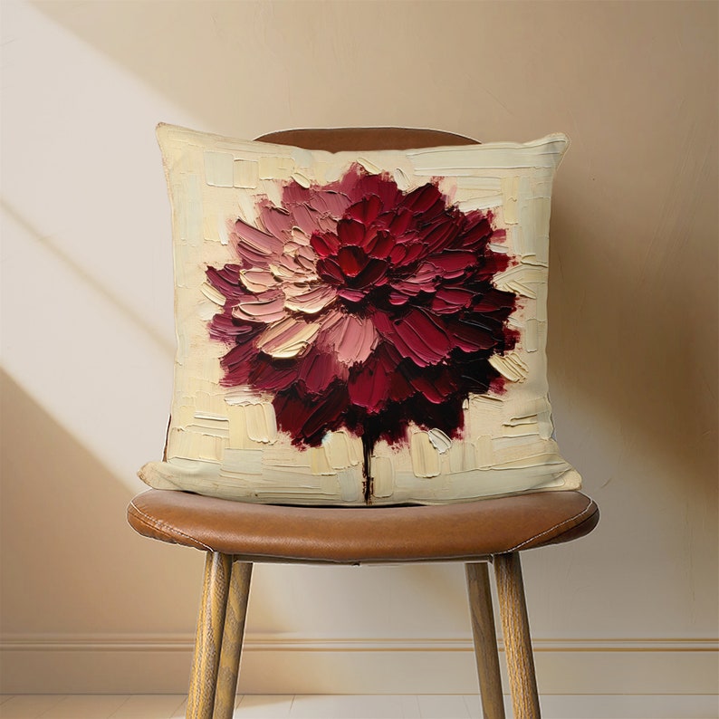 May include: A cream-colored throw pillow with a large, red, pink, and white flower painted on it. The flower is painted in a thick, textured style.