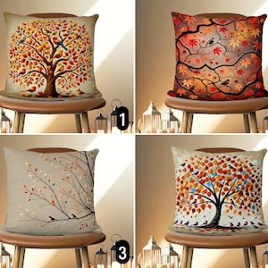 Peut inclure: Quatre designs différents d'oreillers décoratifs représentant des arbres d'automne avec des oiseaux. Les oreillers sont présentés sur des chaises brunes avec un fond clair.