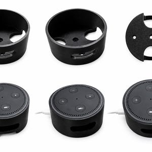 May include: A set of black circular plastic wall mounts for smart speakers. The mounts feature a hollow cylindrical design with cutouts for cables and mounting holes. Three views show the empty mount, the base, and the mount holding a speaker.