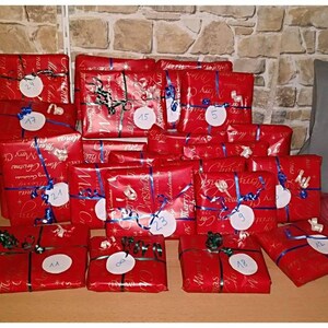 May include: A stack of 18 red gift boxes with blue ribbon and white circles with numbers on them. The boxes are wrapped in red paper with a white pattern that says "Merry Christmas".