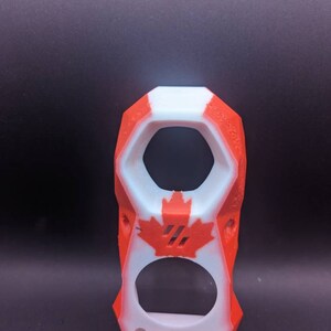May include: A 3D printed phone case with a Canadian flag design. The case is white with red accents and a maple leaf design.