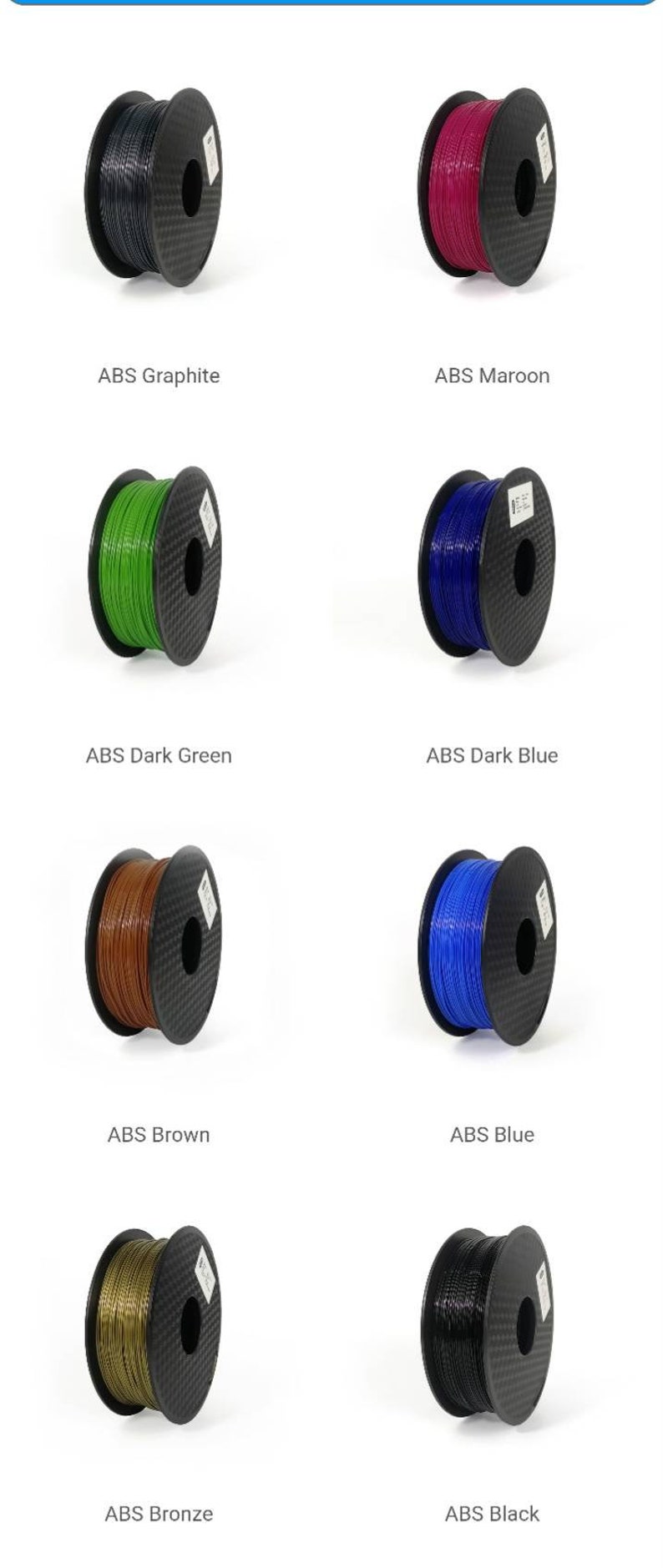 May include: Spools of ABS filament in various colors, including graphite, maroon, dark green, dark blue, brown, blue, bronze, and black.