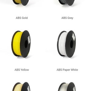 May include: Six spools of 3D printer filament in different colors: gold, gray, yellow, white, beige, and clear. The spools are all black with a carbon fiber pattern.