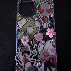 Puede incluir: Una funda transparente para tel&eacute;fono con un fondo brillante y personajes de dibujos animados de la serie animada Invader Zim. Los personajes incluyen a Zim, Gir y Dib. La funda est&aacute; decorada con corazones rosas, estrellas y flores.