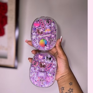 May include: Two clear resin coasters with a purple and pink glitter and various charms, including a heart, a bow, a star, and a paperclip. The top coaster has the text "Aquarius" in white lettering. The bottom coaster has the text "Sweet" in white lettering.