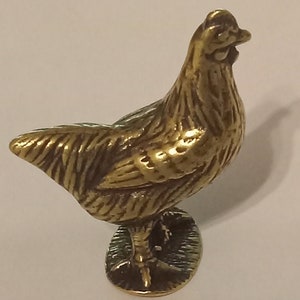 Tiny brass hen figurine.
