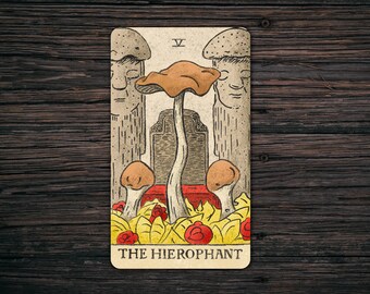 May include: Tarot card illustration of The Hierophant, featuring a mushroom with a brown cap and a white stem, surrounded by smaller mushrooms and leaves. The card is in a vintage style with a yellow background and brown borders. The text "THE HIEROPHANT" is printed at the bottom of the card.