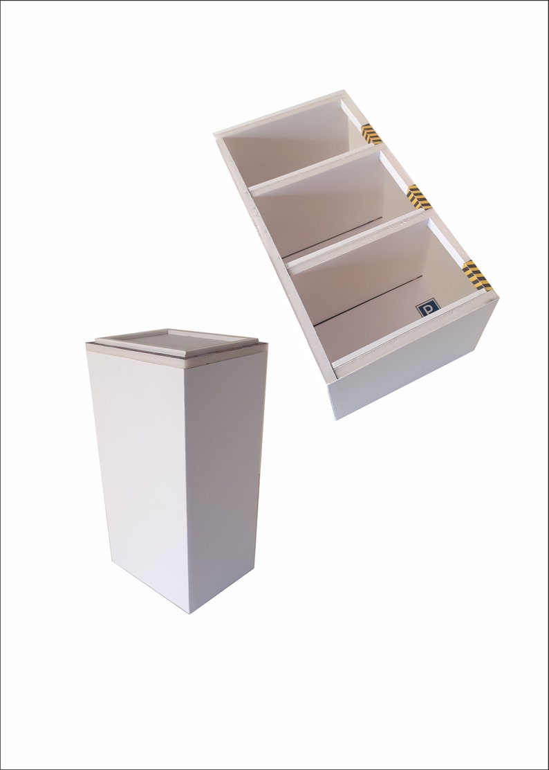 May include: Two white cardboard boxes. One box is a tall rectangular shape with a flat top. The other box is a smaller rectangular shape with three shelves. The shelves have yellow and black caution tape on the edges.