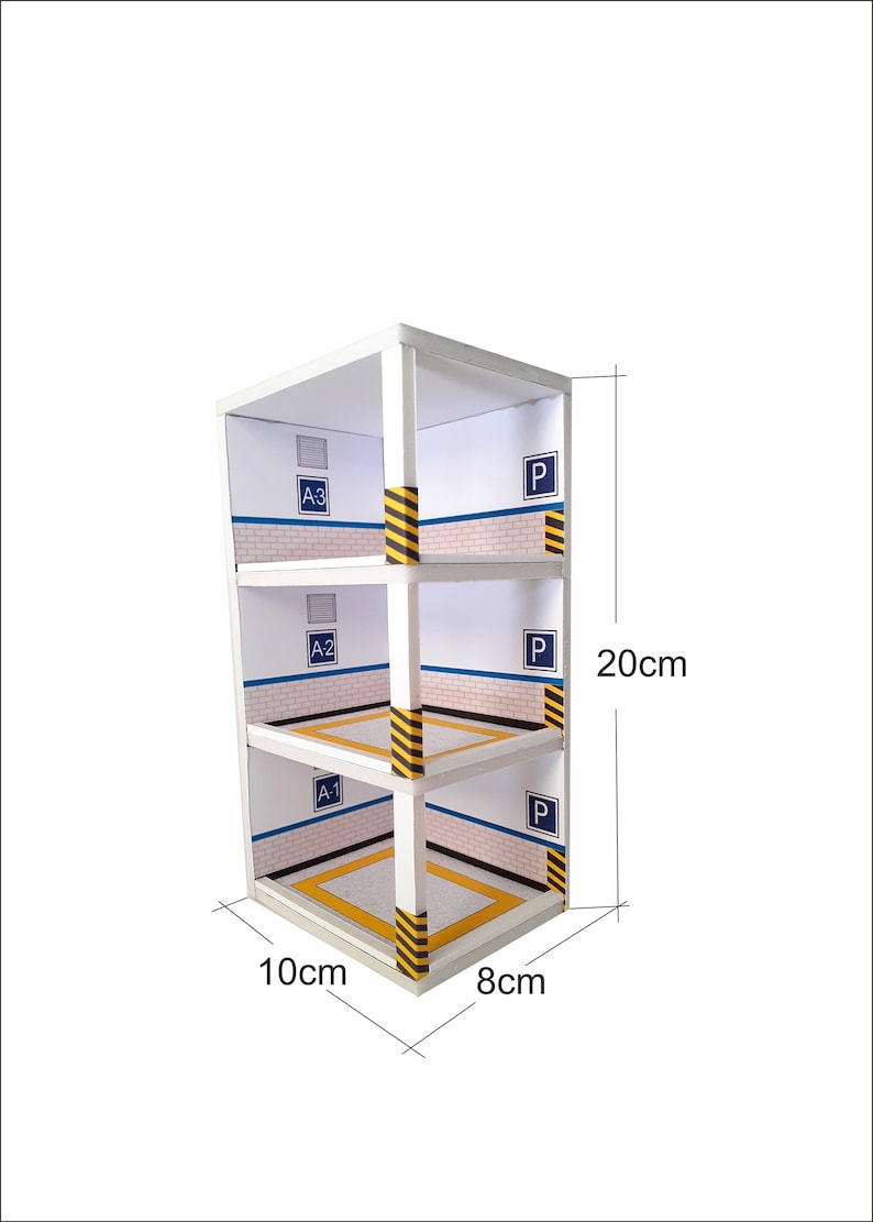 May include: A white cardboard model of a three-level parking garage with yellow and black striped barriers. The garage is labeled with the letters "A-1", "A-2", "A-3", and "P" for parking. The model measures 10 inches wide, 8 inches deep, and 20 inches tall.