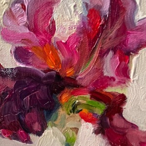 May include: Close-up of a vibrant floral painting. The artwork features a rich palette of colors, including shades of pink, purple, red, orange, green, and white. The brushstrokes are visible, creating a textured effect. The subject appears to be a flower.