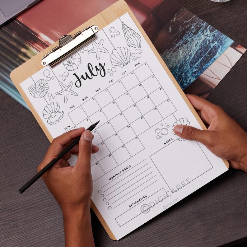 K&ouml;nnte beinhalten: Ein druckbarer Juli-Kalender mit Strandthema. Der Kalender zeigt Muscheln, Seesterne und Blasen. Er bietet Platz f&uuml;r monatliche Ziele, Notizen und eine Affirmation.