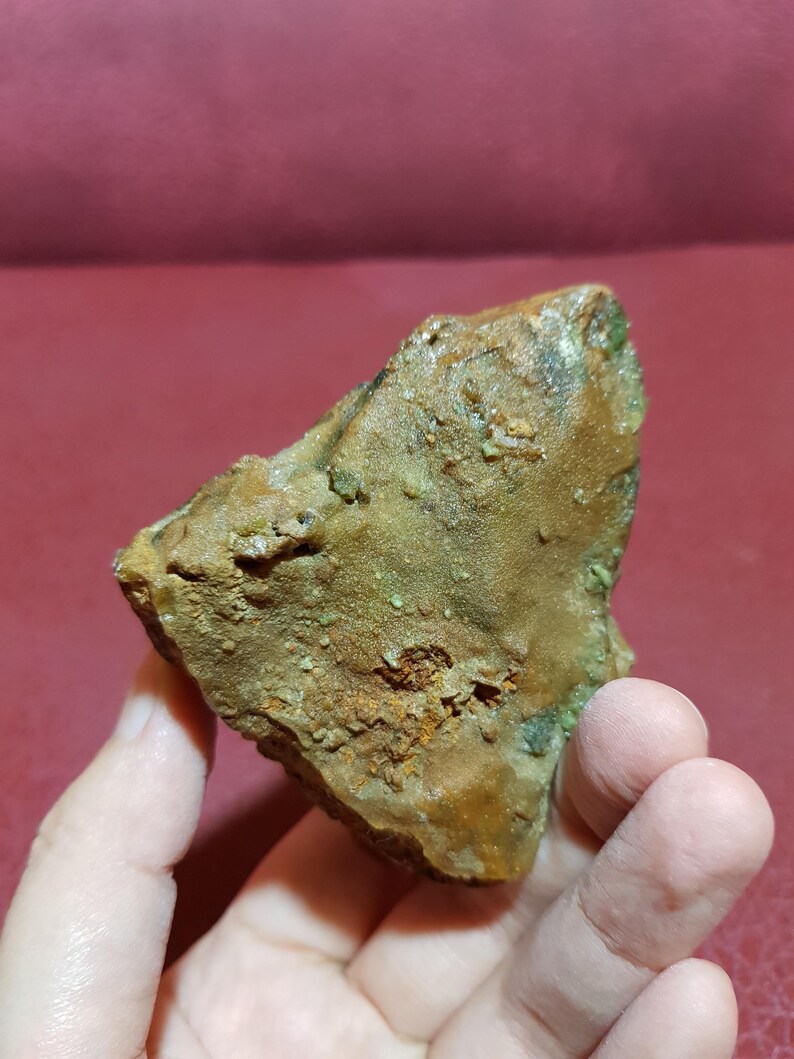 Peut inclure: Une roche brune rugueuse avec des d&eacute;p&ocirc;ts min&eacute;raux verts et orange. La roche est &agrave; peu pr&egrave;s de la taille de la main d'une personne.