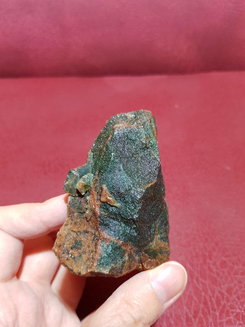 Peut inclure: Une roche brute de couleur verte et brune avec une texture cristalline. La roche a une forme irr&eacute;guli&egrave;re et dentel&eacute;e.