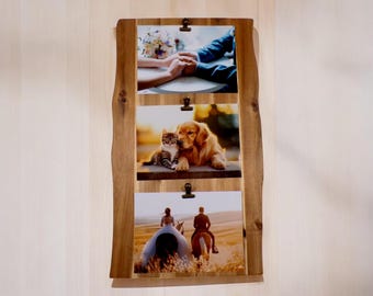 Könnte beinhalten: Ein Holzbildrahmen mit drei Clips, die Fotos halten. Das obere Foto zeigt die Hände eines Paares, die ineinander verschlungen sind. Das mittlere Foto zeigt einen Golden Retriever und eine Katze, die sich aneinanderkuscheln. Das untere Foto zeigt ein Paar, das auf Pferden durch ein Feld reitet.