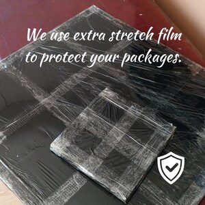 May include: Two packages wrapped in black stretch film, one large and one small, with a white shield icon with a checkmark. The text "We use extra stretch film to protect your packages" is visible.