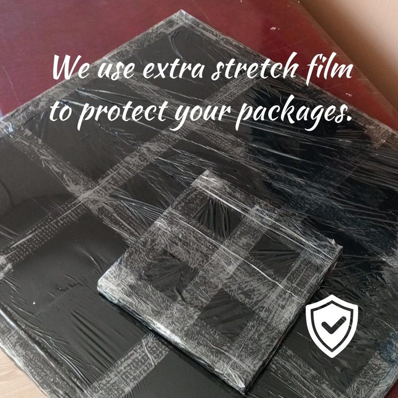 May include: Two packages wrapped in black stretch film, one large and one small, with a white shield icon with a checkmark. The text "We use extra stretch film to protect your packages" is visible.