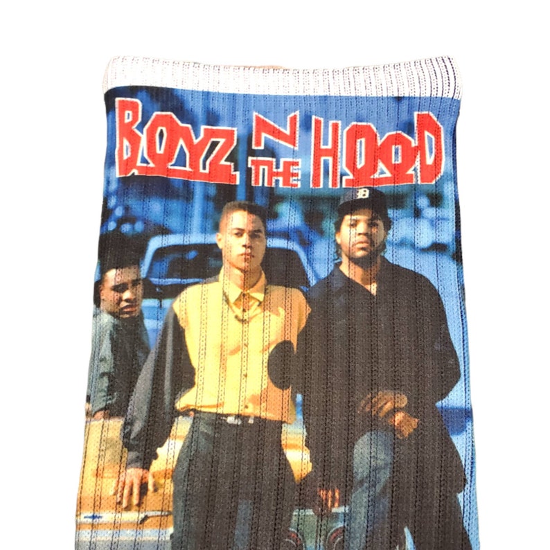 May include: A pair of socks with a blue and white striped pattern. The socks feature a graphic of the movie "Boyz N the Hood" with the title in red letters.