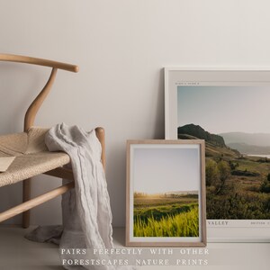 Puede incluir: Dos fotograf&iacute;as de paisajes enmarcadas de un campo de hierba con una monta&ntilde;a en el fondo. La foto superior es una toma amplia de un valle con una monta&ntilde;a en la distancia. La foto inferior es un primer plano de un campo de hierba con una puesta de sol en el fondo. El texto "VALLEY" est&aacute; impreso en la esquina inferior derecha de la foto superior.