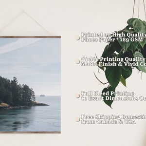 May include: A framed photograph of a scenic landscape with a small island covered in trees and a body of water in the foreground. The sky is a light blue with some clouds. The print is printed on high quality photo paper with a matte finish and vivid colors. The print is full bleed, meaning the image extends to the edges of the paper. The print is available in a variety of sizes.