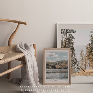 Op de afbeelding: Twee ingelijste landschapsfoto's van een meer en bergen. De bovenste foto toont een bos met hoge bomen en een meer in de verte. De onderste foto toont een meer met bergen op de achtergrond. Beide foto's hebben een vintage esthetiek.