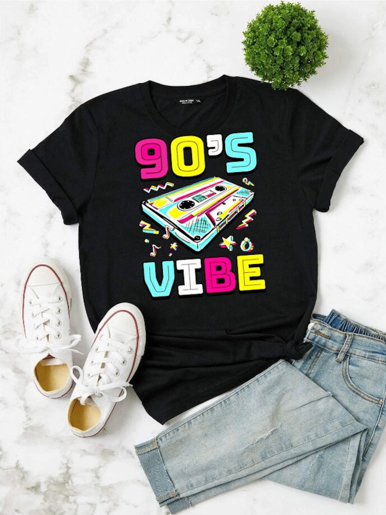 May include: Black t-shirt with a graphic of a cassette tape and the text "90's VIBE" in colorful letters.