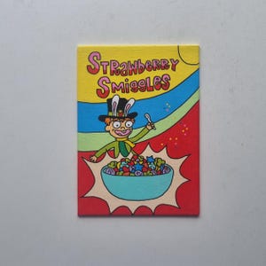 May include: A vibrant painting depicting a cereal box with the words "Strawberry Smiggles". The image shows a cartoon character in a top hat with bunny ears, holding a spoon over a bowl of colourful cereal. The background has a rainbow design.