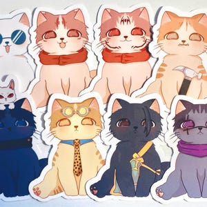 May include: A set of nine stickers featuring cartoon cats in various poses and outfits. The cats are all wearing different accessories, such as glasses, scarves, and hats. The stickers are printed on white paper and have a glossy finish.