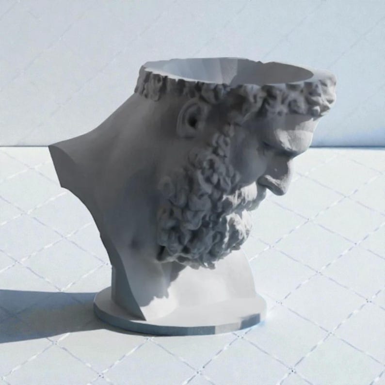 May include: A light gray, hollow bust of a bearded figure with a classical aesthetic, featuring a circular opening at the top of the head. The sculpture depicts a profile view of a person with curly hair and a thick beard, set on a circular base.