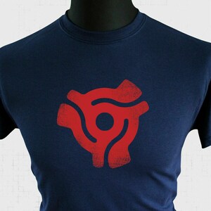 May include: A navy blue t-shirt with a red vinyl record adapter symbol printed on the front.