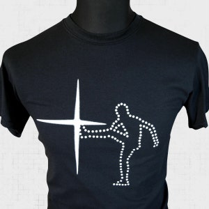 May include: Black t-shirt with a white graphic of a person standing next to a large white star.