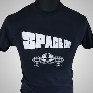 May include: A black t-shirt featuring a white graphic of the text "SPACE: 1999" and a spaceship.