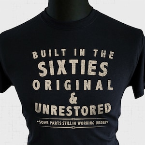 May include: Black t-shirt with a vintage-style graphic that reads "Built in the Sixties Original & Unrestored. Some parts still in working order."