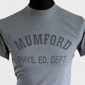 May include: A gray t-shirt with the text "MUMFORD PHYS. ED. DEPT." printed on the front.
