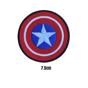 May include: An embroidered patch featuring a white star on a blue circle surrounded by a red circle with a white outline. The patch is 7.5 cm in diameter.